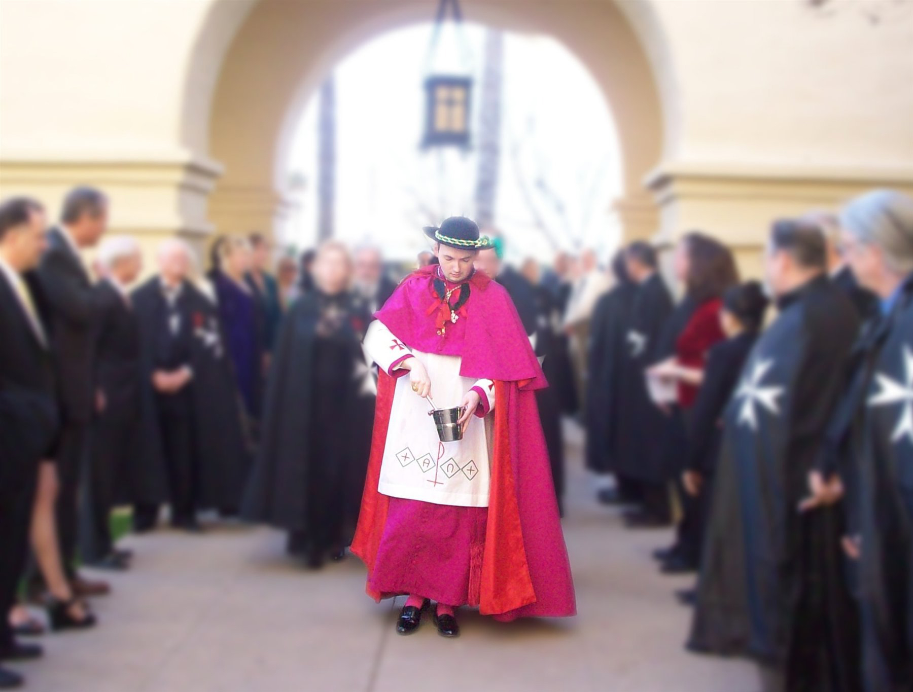 Cardinal Rutherford Johnson blessing candidates for investiture with holy water